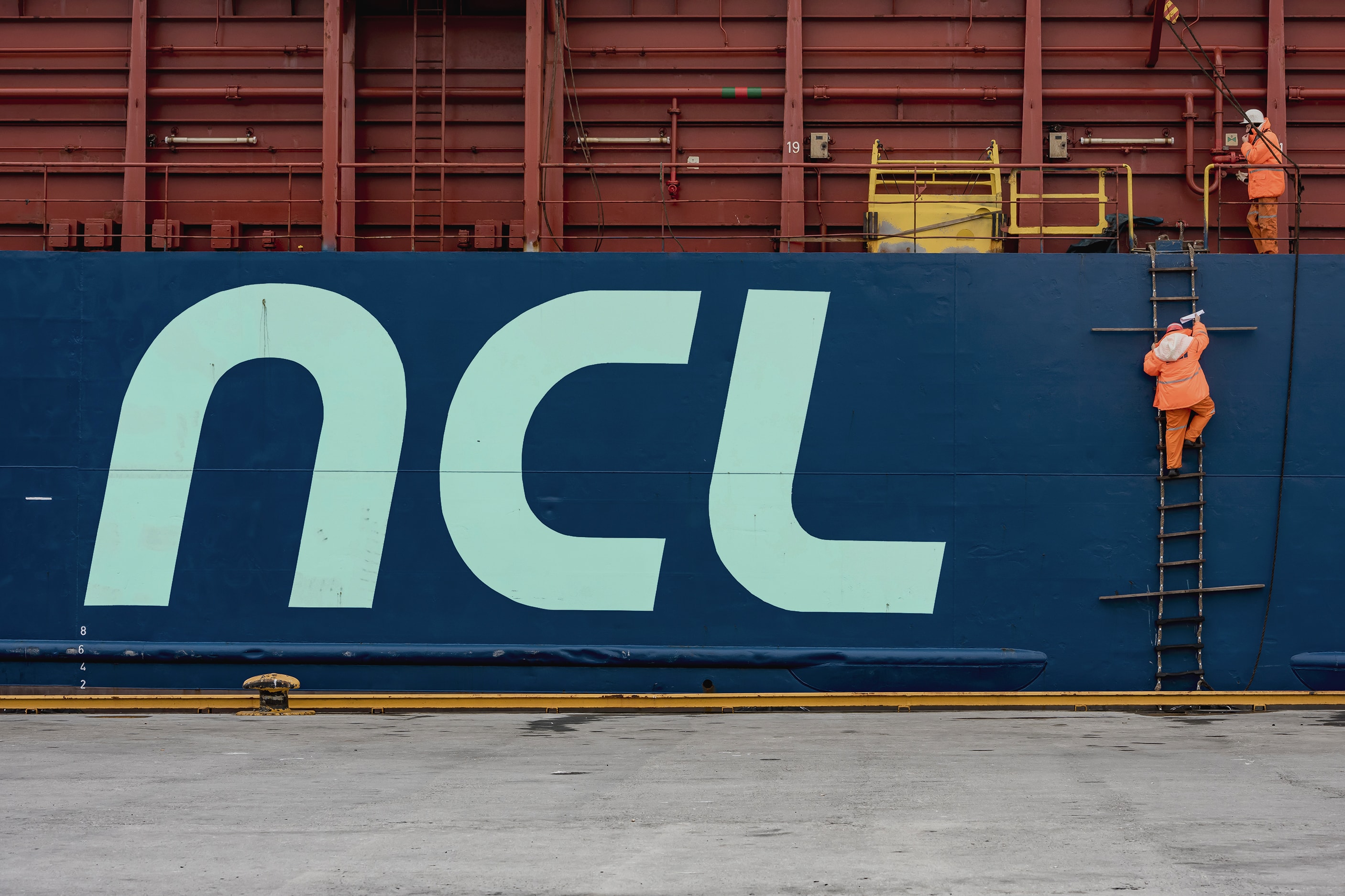 NCL-logoen på siden av et lasteskip i havn