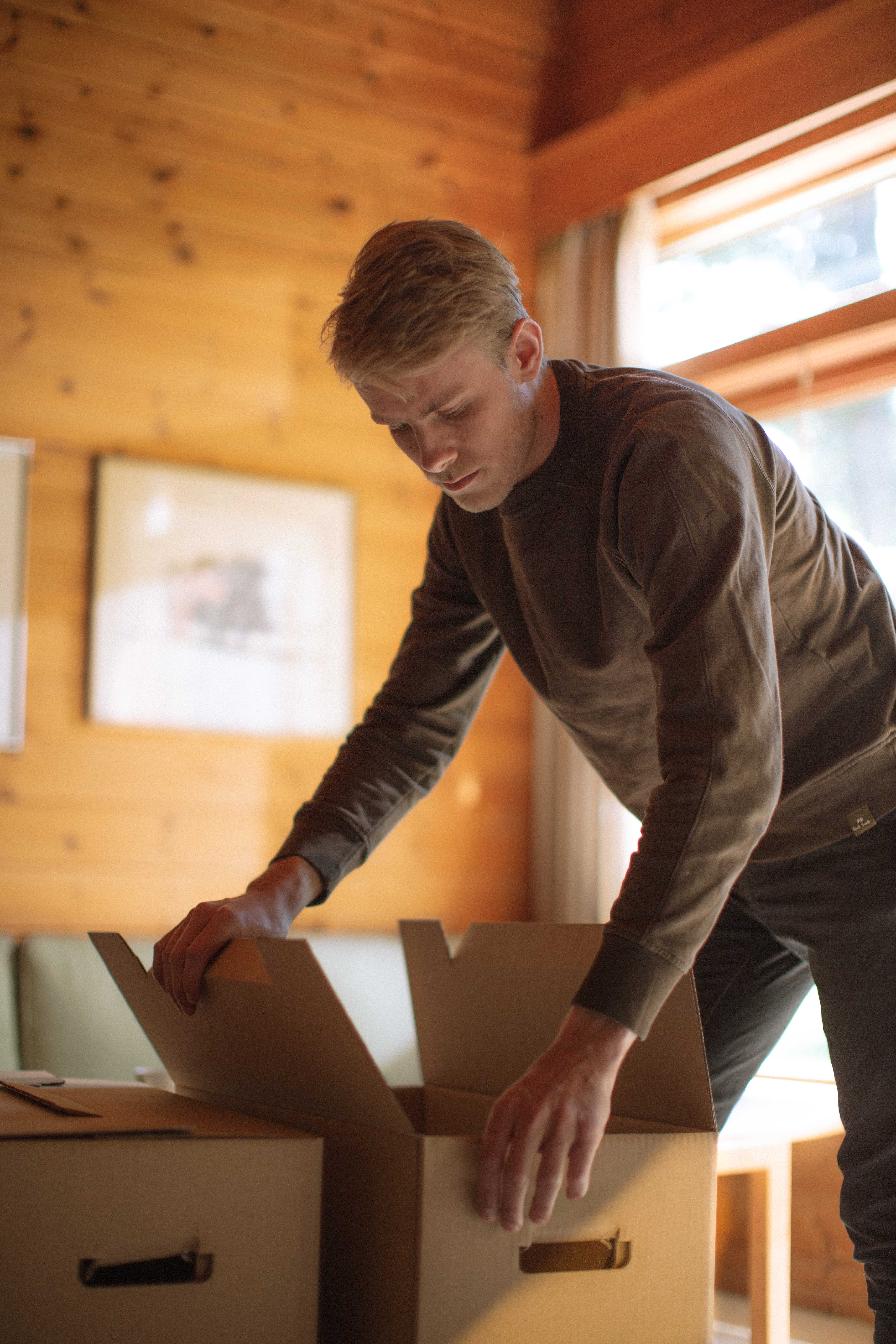 En person pakker flytteesker i en bolig
