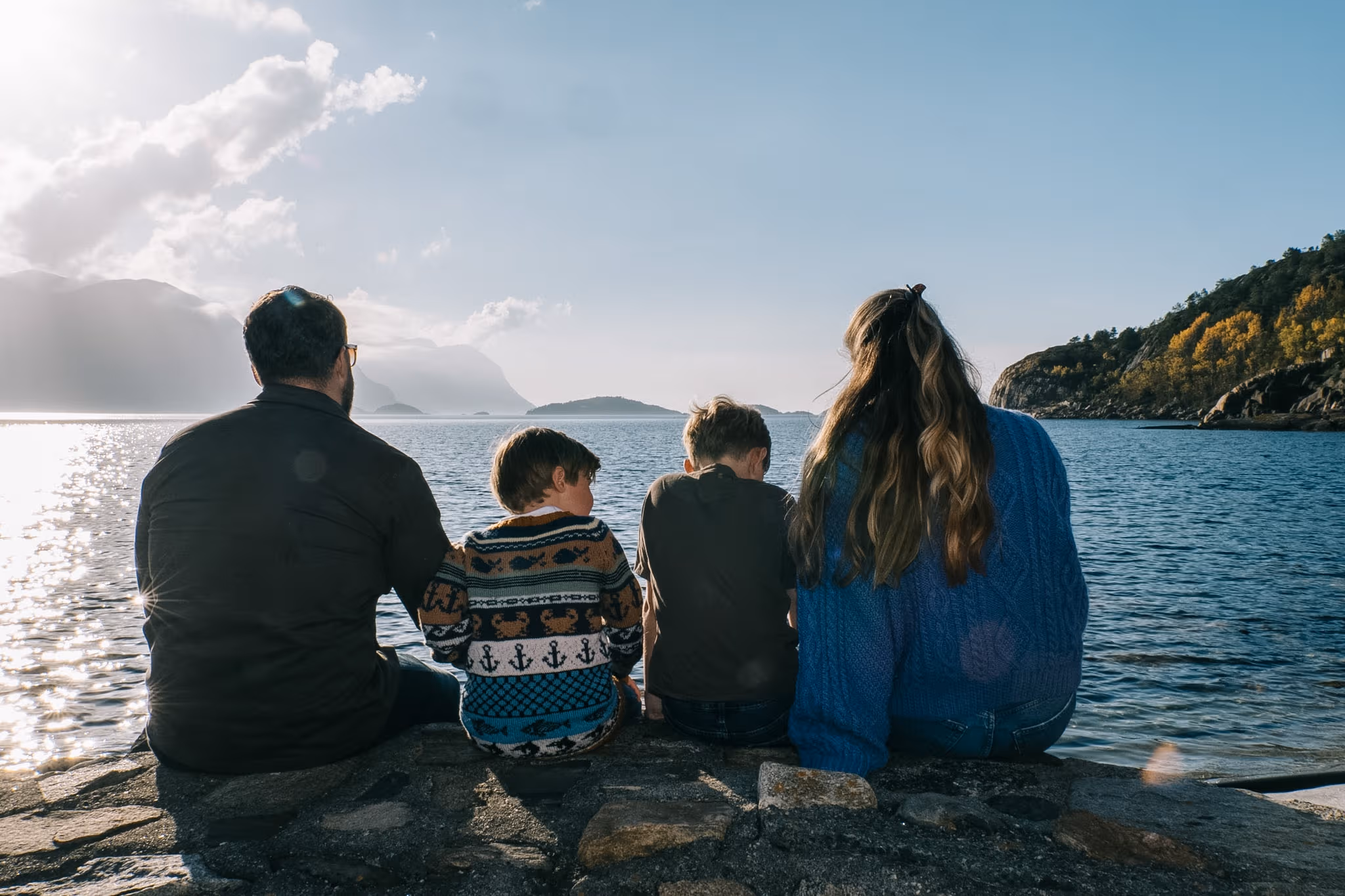 Gustav og familien sitter sammen ved fjorden